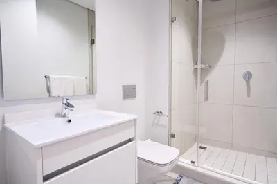 a bathroom with a sink and a toilet and a shower at MaZZ at Ellipse Waterfall in Midrand