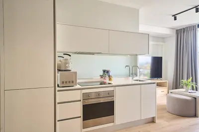 a kitchen with white cabinets and a stove at MaZZ at Ellipse Waterfall in Midrand