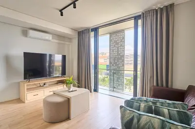 a living room with a flat screen tv and a couch at MaZZ at Ellipse Waterfall in Midrand