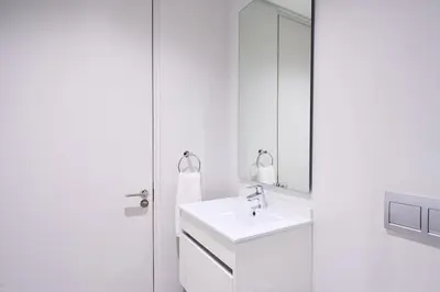 a white bathroom with a sink and a mirror at MaZZ at Ellipse Waterfall in Midrand