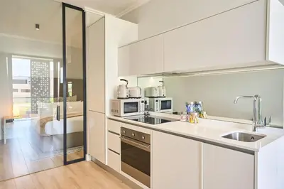 a white kitchen with a sink and a microwave at MaZZ at Ellipse Waterfall in Midrand