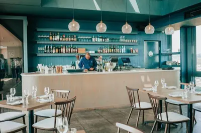 a man standing at the bar of a restaurant at Menlyn Maine Trilogy Apartment 1101 in Pretoria