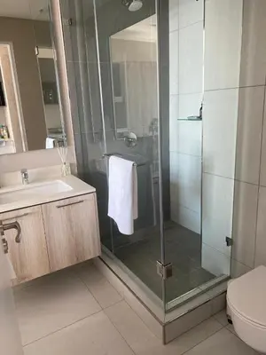 a bathroom with a shower and a toilet and a sink at Menlyn Maine Trilogy Apartment 1101 in Pretoria