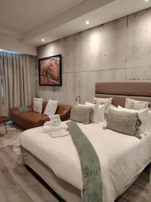 a bedroom with a large bed and a couch at Menlyn Maine Trilogy Apartment 1101 in Pretoria