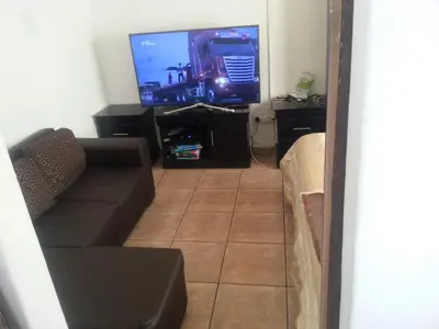 a living room with a couch and a flat screen tv at Luxury 3-Bedroom Apartment in Midrand in Midrand