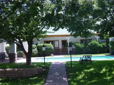 a house with a tree and a swimming pool at Sunninghill Guest Lodges in Johannesburg