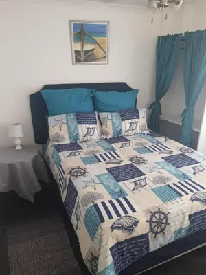 a bedroom with a bed with a quilt on it at Cottage1 at Cynthias Country in Hartbeespoort