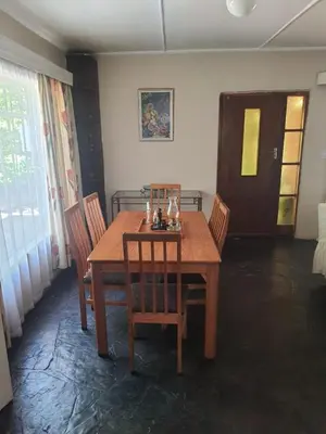 a wooden table and chairs in a room at Cottage1 at Cynthias Country in Hartbeespoort