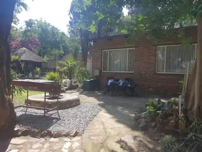 a backyard with a table and chairs and a brick building at Cottage1 at Cynthias Country in Hartbeespoort