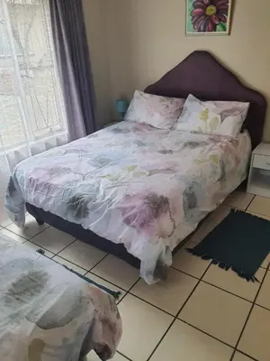 a bedroom with a bed and a dog on the floor at Cottage1 at Cynthias Country in Hartbeespoort