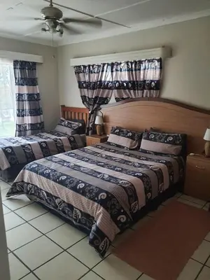 a bedroom with two beds and a ceiling at Cottage1 at Cynthias Country in Hartbeespoort