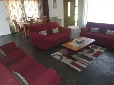a living room with red couches and a coffee table at Cottage1 at Cynthias Country in Hartbeespoort