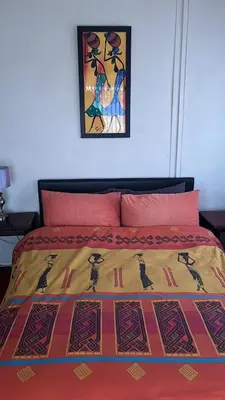 a bed with a colorful blanket on top of it at Cynthias Country Farm Stay 5bedroom in Hartbeespoort