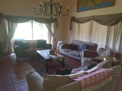 a living room with couches and a chandelier at Cynthias Country Farm Stay 5bedroom in Hartbeespoort