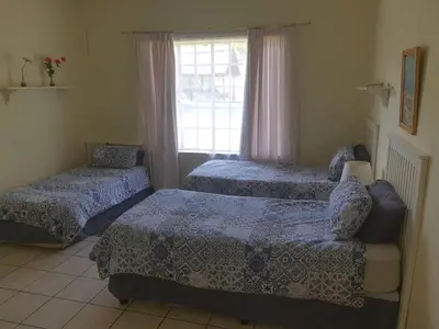 a bedroom with two beds and a window at Cynthias Country Farm Stay 5bedroom in Hartbeespoort
