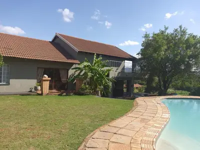 a house with a swimming pool in front of a house at Cynthias Country Farm Stay 5bedroom in Hartbeespoort
