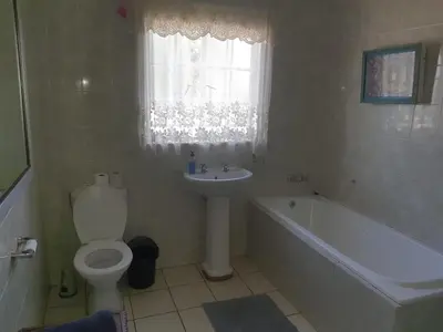 a bathroom with a toilet and a sink and a bath tub at Cynthias Country Farm Stay 5bedroom in Hartbeespoort