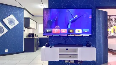a living room with a tv and a white entertainment center at Family Elegant Smart Home in Midrand