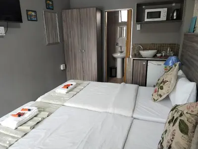 a bedroom with a bed with two towels on it at DAMOFUS Guest House in Pretoria