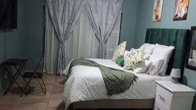 a bedroom with a bed with white sheets and pillows at SIMICON Guesthouse in Witbank