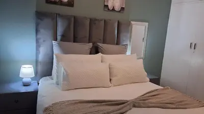 a bedroom with a large bed with white pillows at SIMICON Guesthouse in Witbank