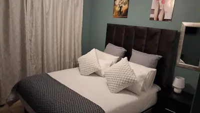 a bedroom with a bed with white pillows at SIMICON Guesthouse in Witbank