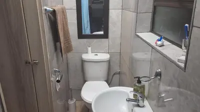 a small bathroom with a toilet and a sink at SIMICON Guesthouse in Witbank