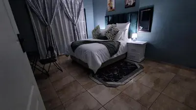 a bedroom with a bed and a lamp on a table at SIMICON Guesthouse in Witbank