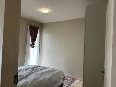 a bedroom with a bed and a window at Cairo properties in Polokwane