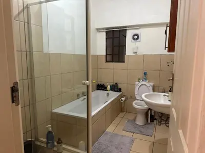 a bathroom with a tub and a toilet and a sink at Cairo properties in Polokwane