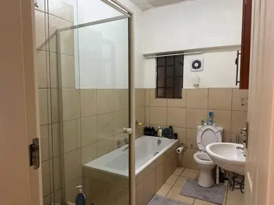 a bathroom with a tub and a toilet and a sink at Cairo properties in Polokwane