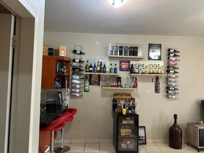 a bar with a red stool and bottles on the wall at Cairo properties in Polokwane
