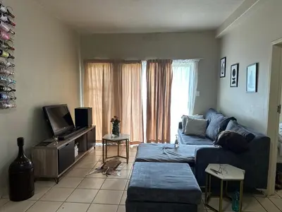 a living room with a blue couch and a tv at Cairo properties in Polokwane