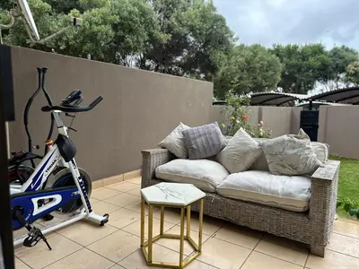 a couch and a bike on a patio with a scooter at Cairo properties in Polokwane