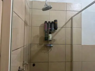a bathroom with a shower with bottles on a shelf at Cairo properties in Polokwane