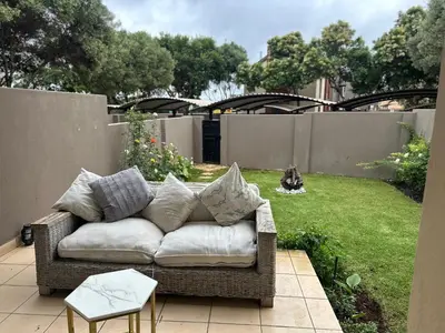 a couch sitting on a patio in a yard at Cairo properties in Polokwane