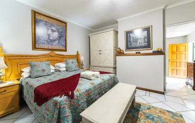 a bedroom with a large bed and a table at 210 Guest in Kempton Park