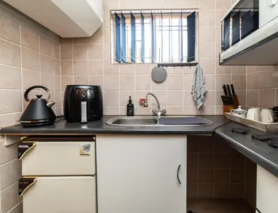 a kitchen with a sink and a microwave at 210 Guest in Kempton Park