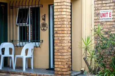 two white chairs sitting on the porch of a house at 210 Guest in Kempton Park