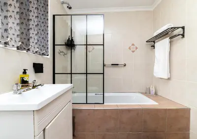 a bathroom with a tub and a sink and a shower at 210 Guest in Kempton Park