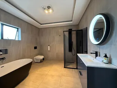 a bathroom with a tub and a toilet and a sink at JuaMtoto guesthouse in Pretoria