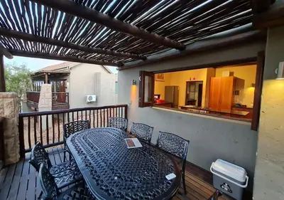 a balcony with a table and chairs on a deck at Valley View Elements 4 Bedroom in Warmbaths