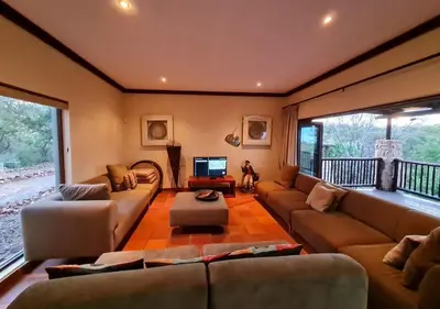 a living room with two couches and a television at Valley View Elements 4 Bedroom in Warmbaths