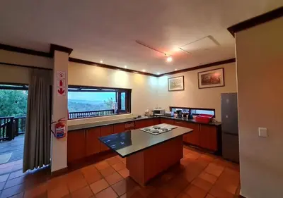 a large kitchen with a counter and a large window at Valley View Elements 4 Bedroom in Warmbaths