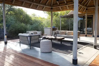 a patio with couches and tables on a deck at Villa White Lion - Luxurious Villa nearby Kruger in Hoedspruit
