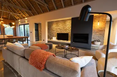 a living room with a large couch and a fireplace at Villa White Lion - Luxurious Villa nearby Kruger in Hoedspruit