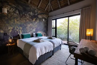 a bedroom with a large bed and a large window at Villa White Lion - Luxurious Villa nearby Kruger in Hoedspruit