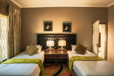 two beds in a room with two lamps at Ramandire B&B in Witbank