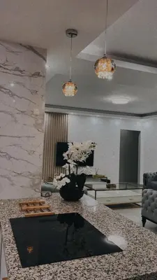 a living room with a table with a vase of flowers at Zaidi Luxury Home in Secunda