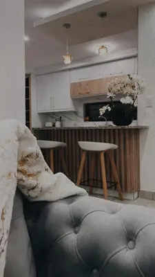 a living room with a couch and a kitchen at Zaidi Luxury Home in Secunda